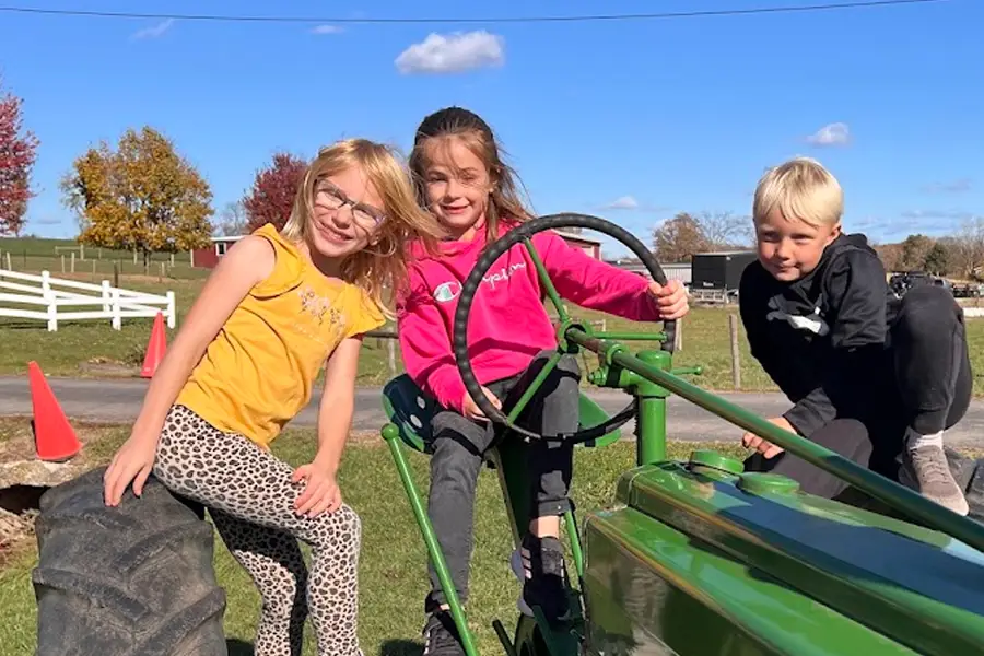 kids on a tractor post for a photo on a field trip