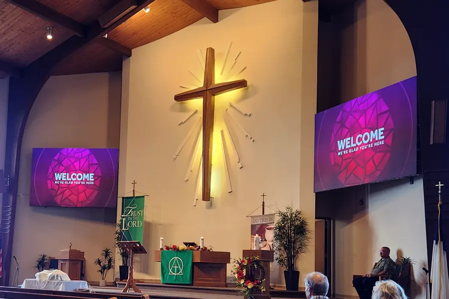 altar with welcome message on the screens to the sides of the altar