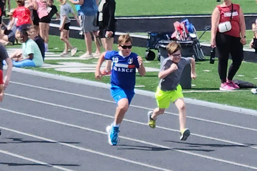 two boys running race on track
